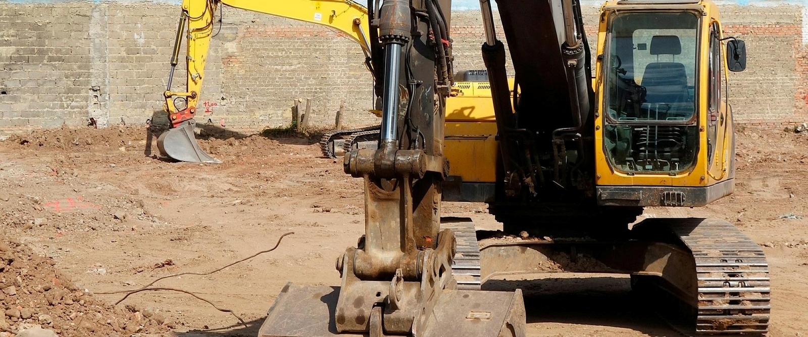 To gravemaskiner der fjerner jord efter nedbrydning af bygning i Thisted.